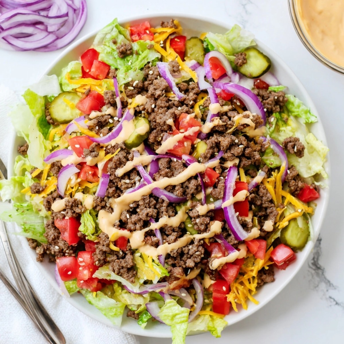 Overhead view of the Big Mac Salad, a gluten-free burger bowl with sesame garnish.