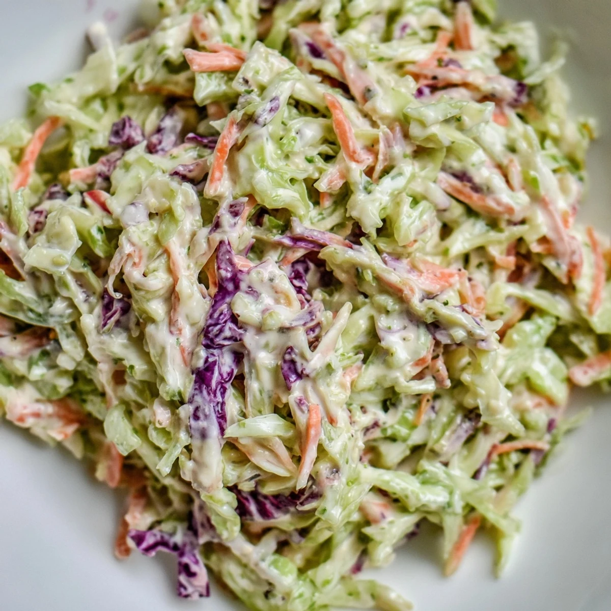 Freshly made creamy coleslaw featuring crisp, colorful vegetables, excellent as a side dish for any meal.
