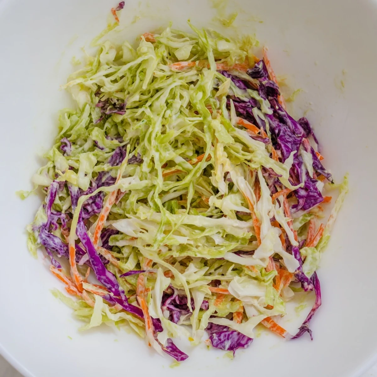 Creamy coleslaw with vibrant shredded cabbage, carrots, and a luscious, tangy dressing served chilled.