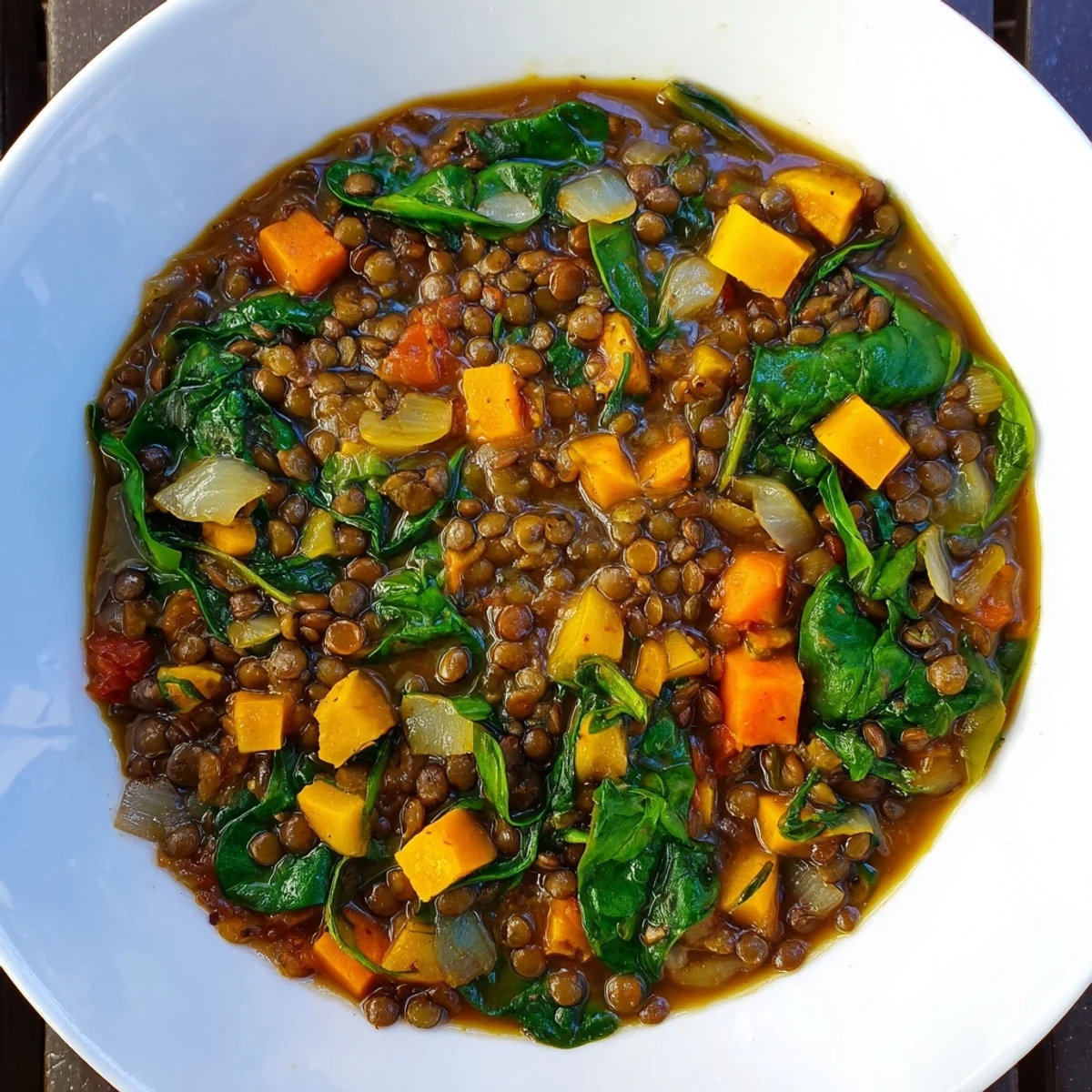 Steaming bowl of Savory Lentil and Spinach Stew, a vibrant and veggie-packed Mediterranean delight.