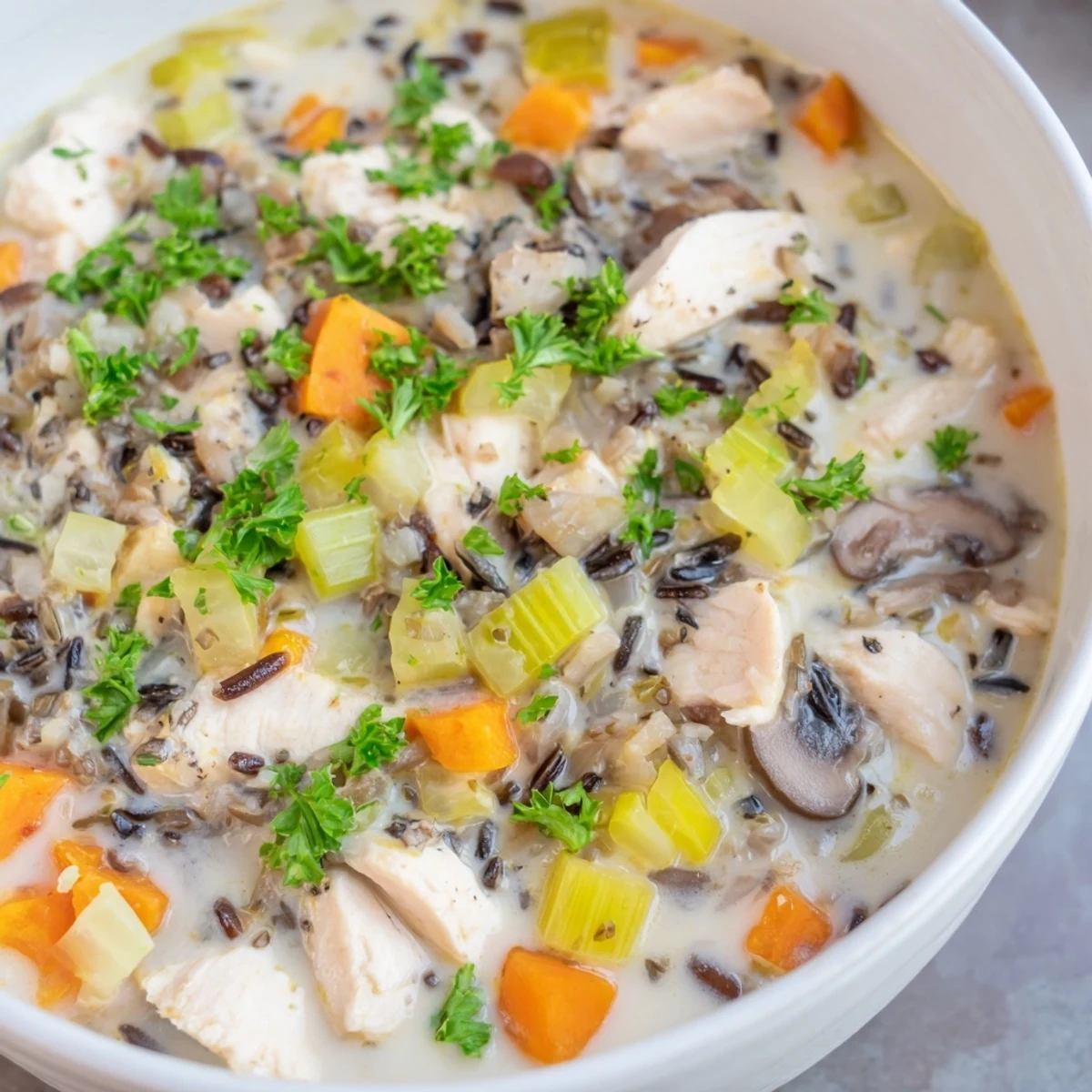A close-up shot of the rich, creamy texture of this homemade Creamy Chicken and Wild Rice Soup.