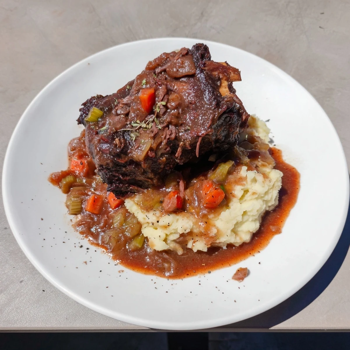 Tender, fall-off-the-bone braised beef short ribs served with creamy mashed potatoes, dripping in rich sauce.