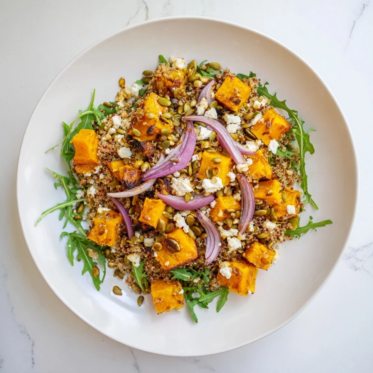 Hearty Winter Squash and Quinoa Salad featuring colorful arugula, and toasted pumpkin seeds, visually appealing.
