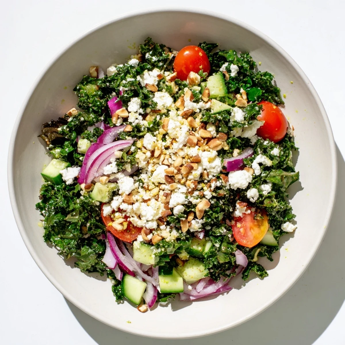 This Kale Salad shows a close-up of tender kale leaves with crunchy almonds and feta cheese.