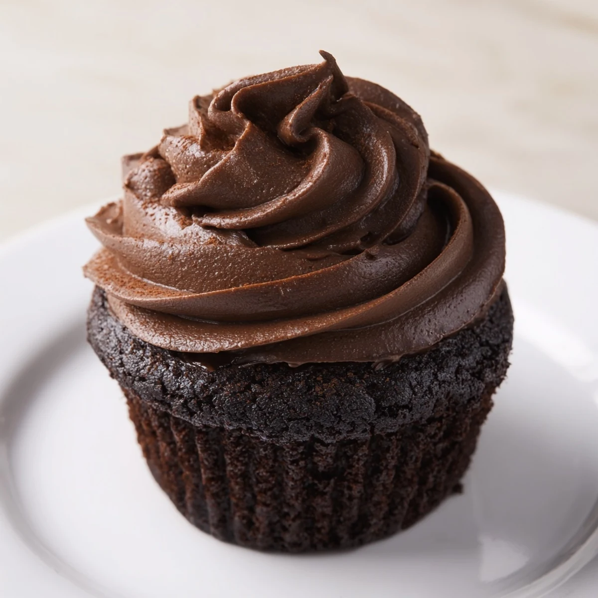 Close-up of freshly baked chocolate cupcakes, frosted with swirls of creamy chocolate buttercream.