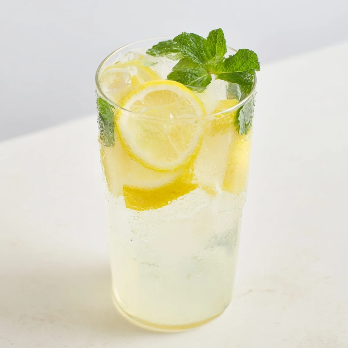Glass of glistening, homemade lemonade, enhanced with lemon slices for an appealing visual.