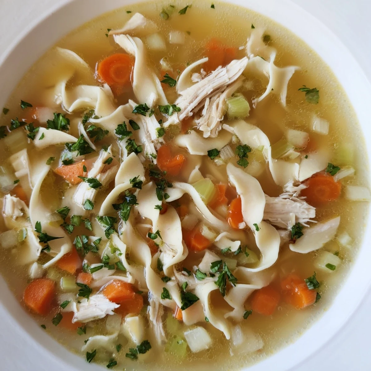 Hearty Chicken Noodle Soup served in a white bowl, ready to be enjoyed with family.
