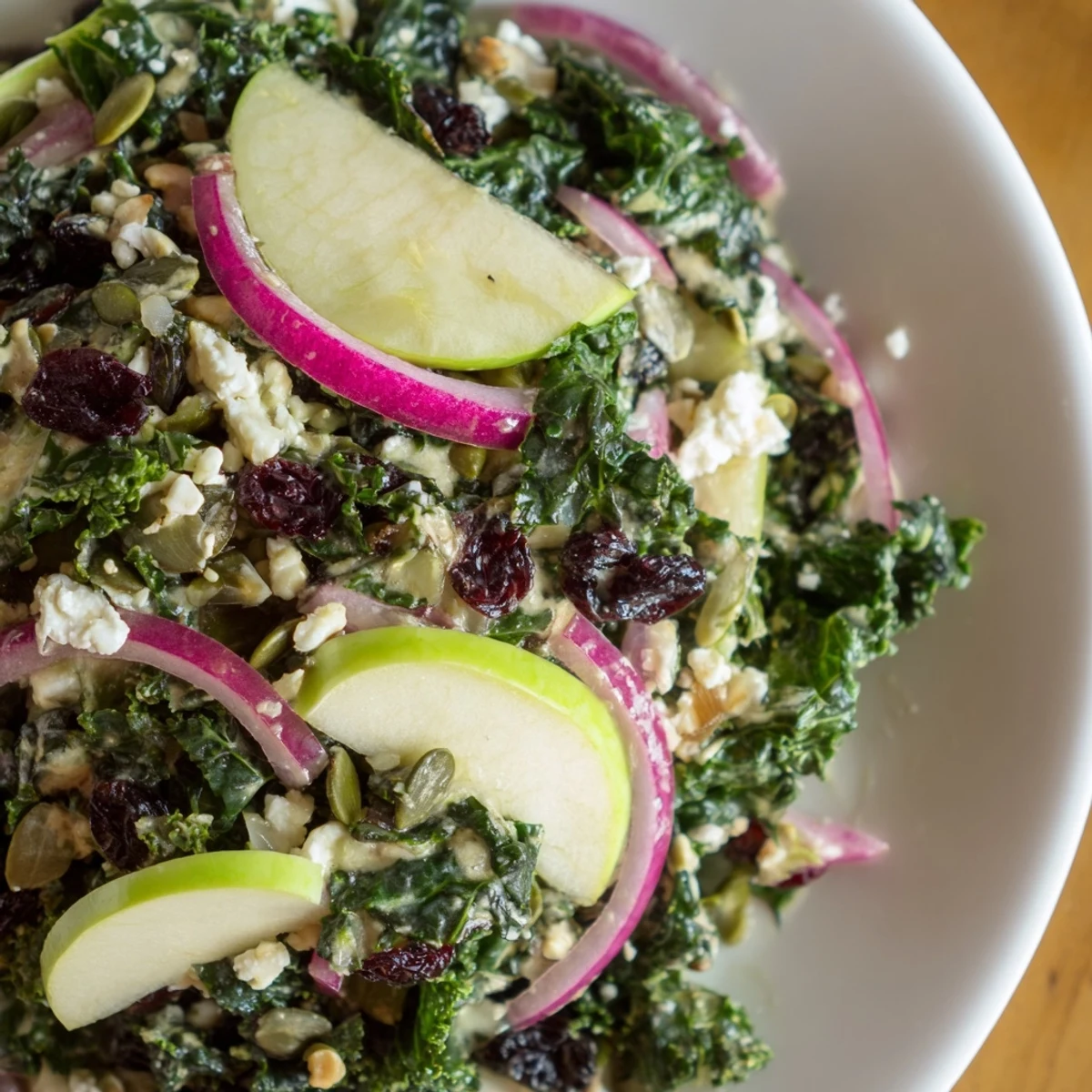 Fresh kale is massaged for a tender Winter Kale Salad with Cranberries and Seeds, topped with feta and seeds.
