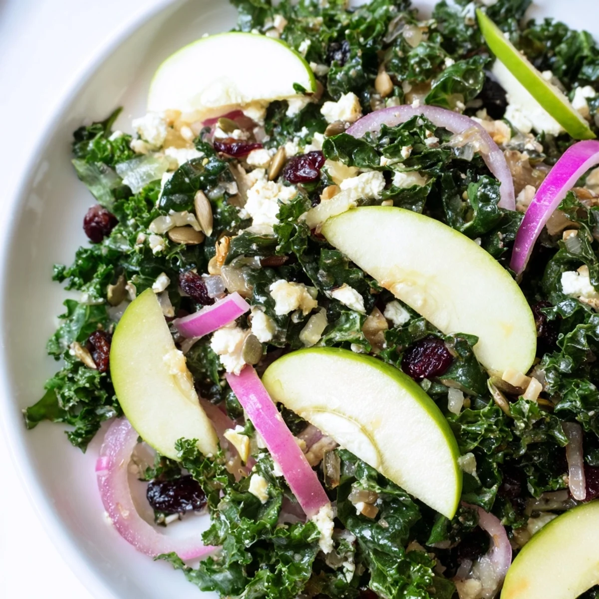 Winter Kale Salad with Cranberries and Seeds is tossed in a large bowl, ready for a healthy vegetarian dinner.