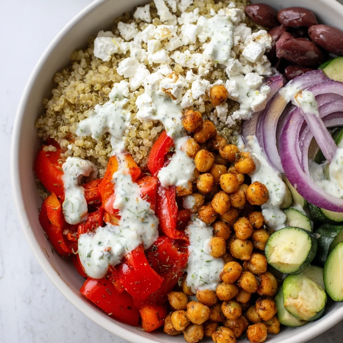 Spoonful of fluffy quinoa topped with olives and fresh herbs in this Mediterranean Dinner Bowl, perfect for a healthy weeknight meal.