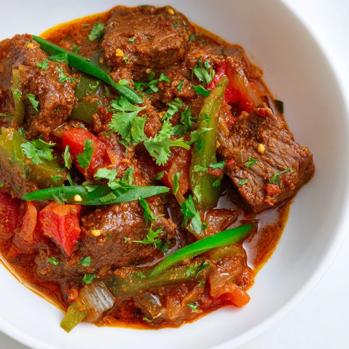 Tender beef cubes simmer in a spicy, aromatic curry sauce with coconut milk and warming spices, garnished with fresh cilantro.