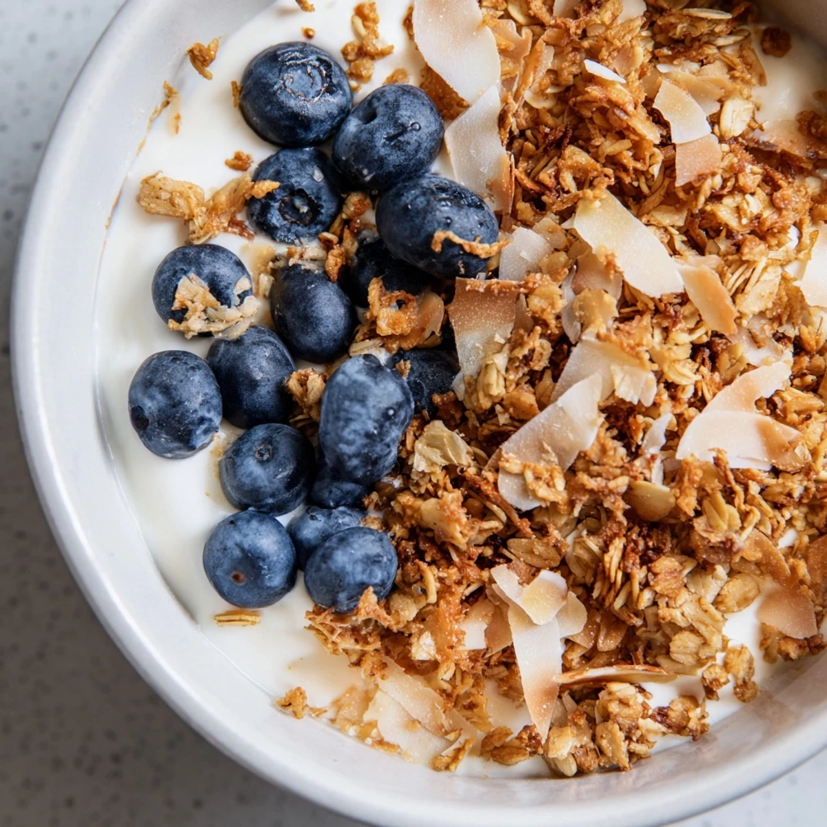 A vibrant close-up of layered Lemon Blueberry Yogurt Parfait with creamy yogurt, honey drizzle, and crunchy granola.