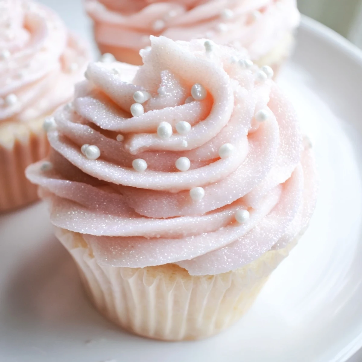 Freshly baked Pink Champagne Cupcakes with soft crumb and sparkling alcohol-free champagne buttercream frosting.