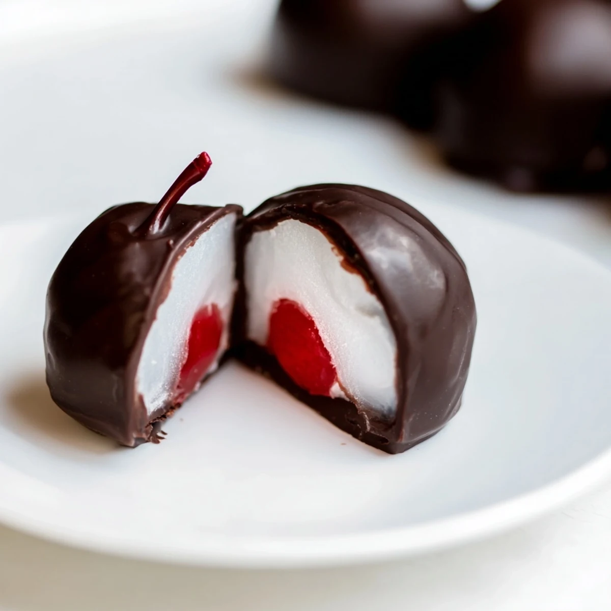 A close-up of a chocolate covered cherries with fondant center, showing rich chocolate and a peek of sweet fondant.