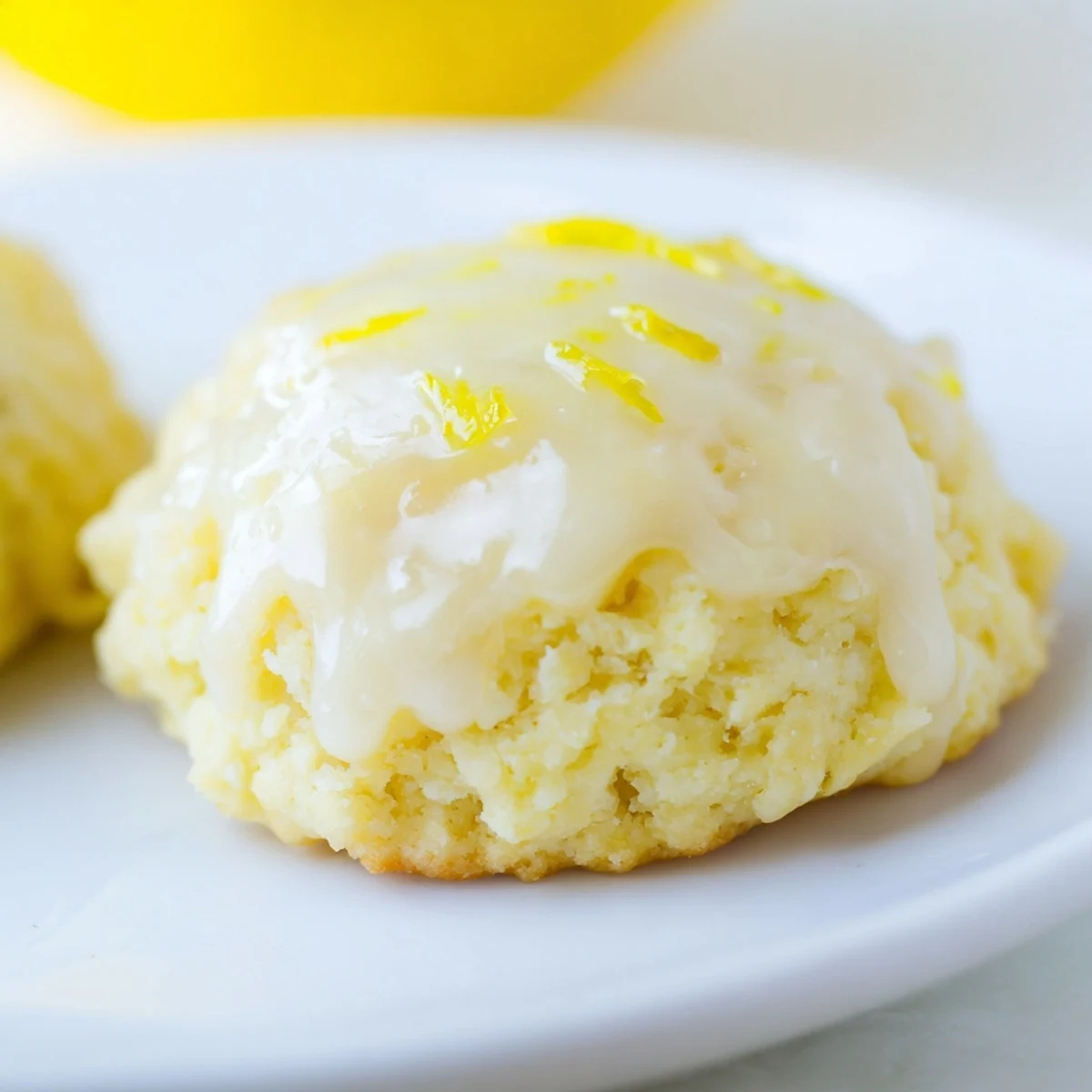 Soft, cake-like Lemon Ricotta Cookies drizzled with sweet-tart lemon glaze, served alongside a steaming cup of coffee.