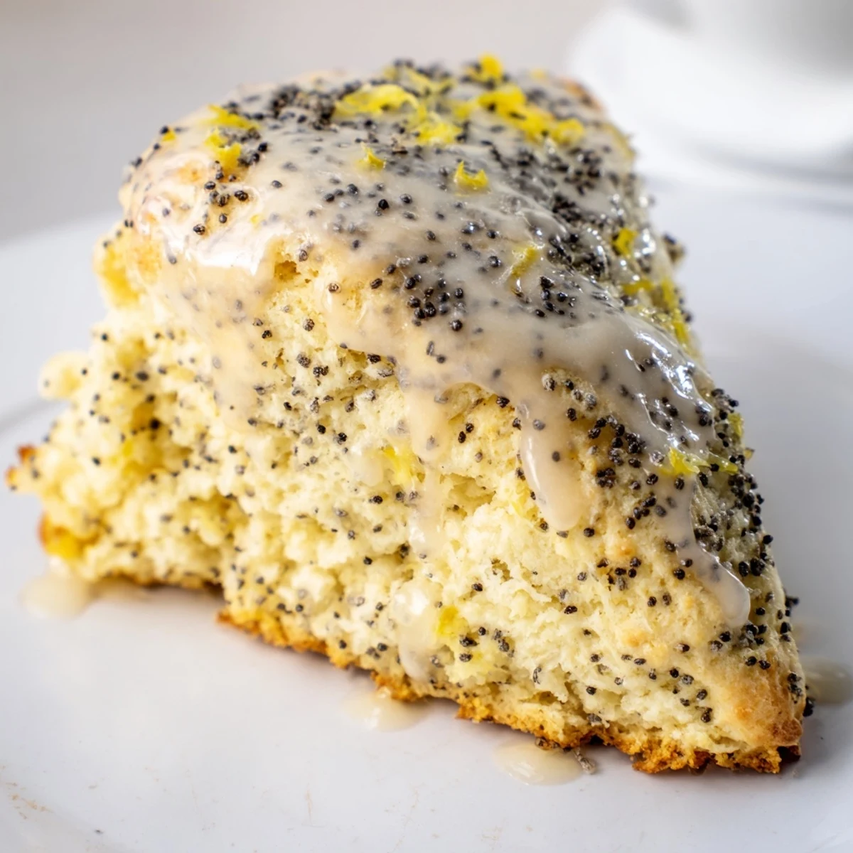 Golden-brown Lemon Poppy Seed Scones showing the crunchy poppy seeds and zesty glaze.
