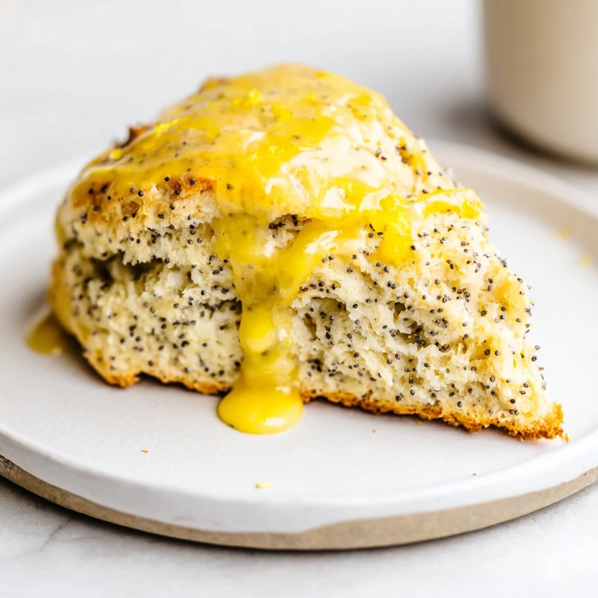 Close-up of Lemon Poppy Seed Scones showing fluffy texture and poppy seeds on a marble surface.