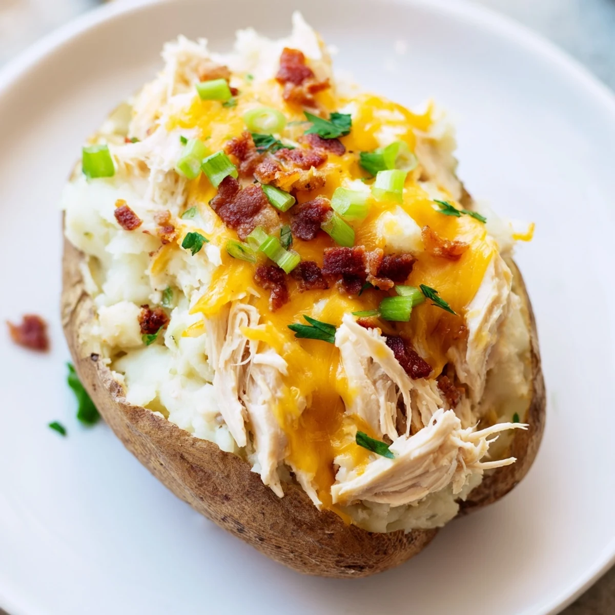 A close-up of Mud Chicken Stuffed Twice Baked Potatoes with Savory Filling, showing the rich chicken and potato filling inside crispy potato skins.