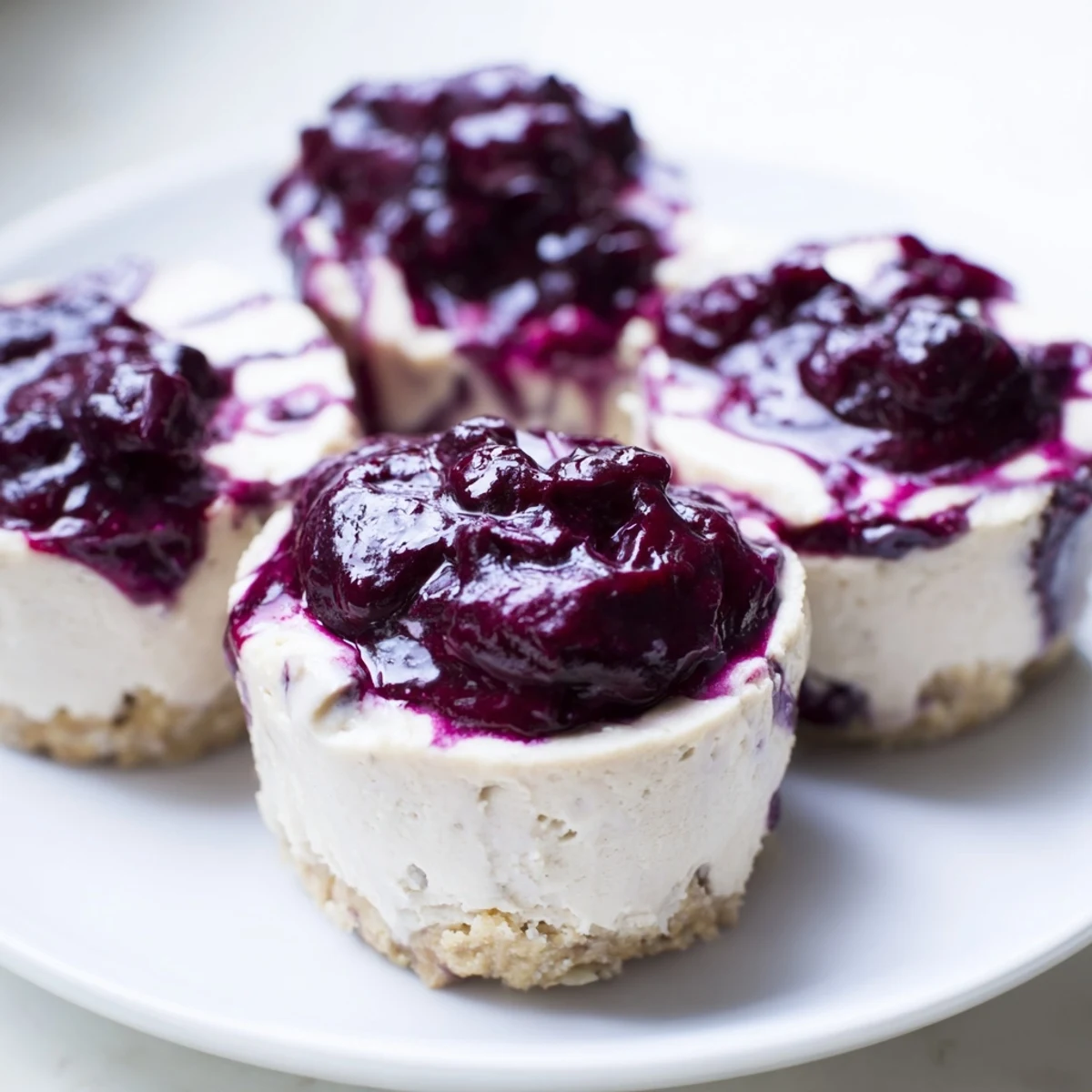A close-up of Blueberry Cheesecake Protein Bites on a marble board, showing the creamy filling and juicy blueberry swirl.