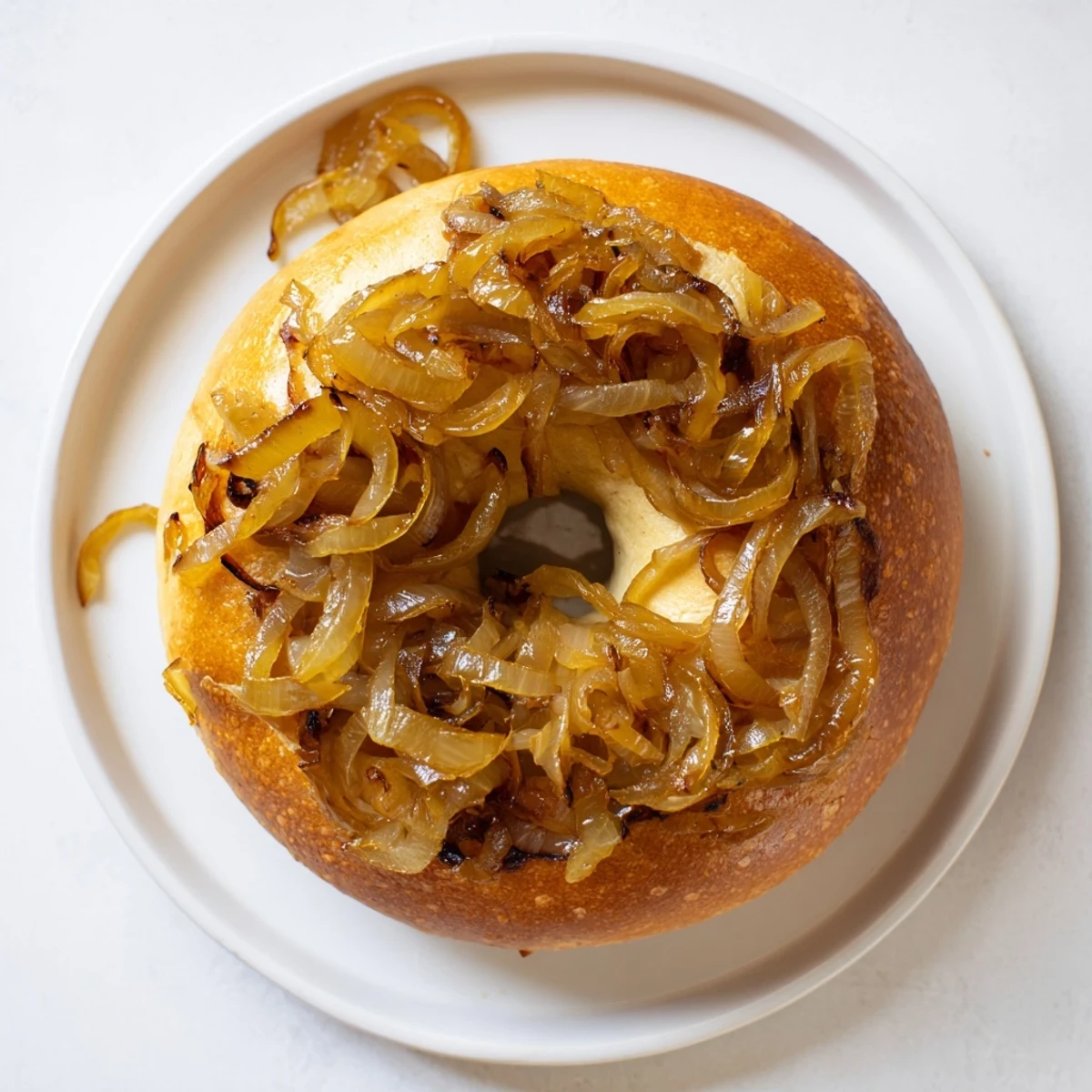 Chewy Sourdough Onion Bagels with tangy sourdough flavor and savory onion topping, stacked on a wire rack for cooling after baking.