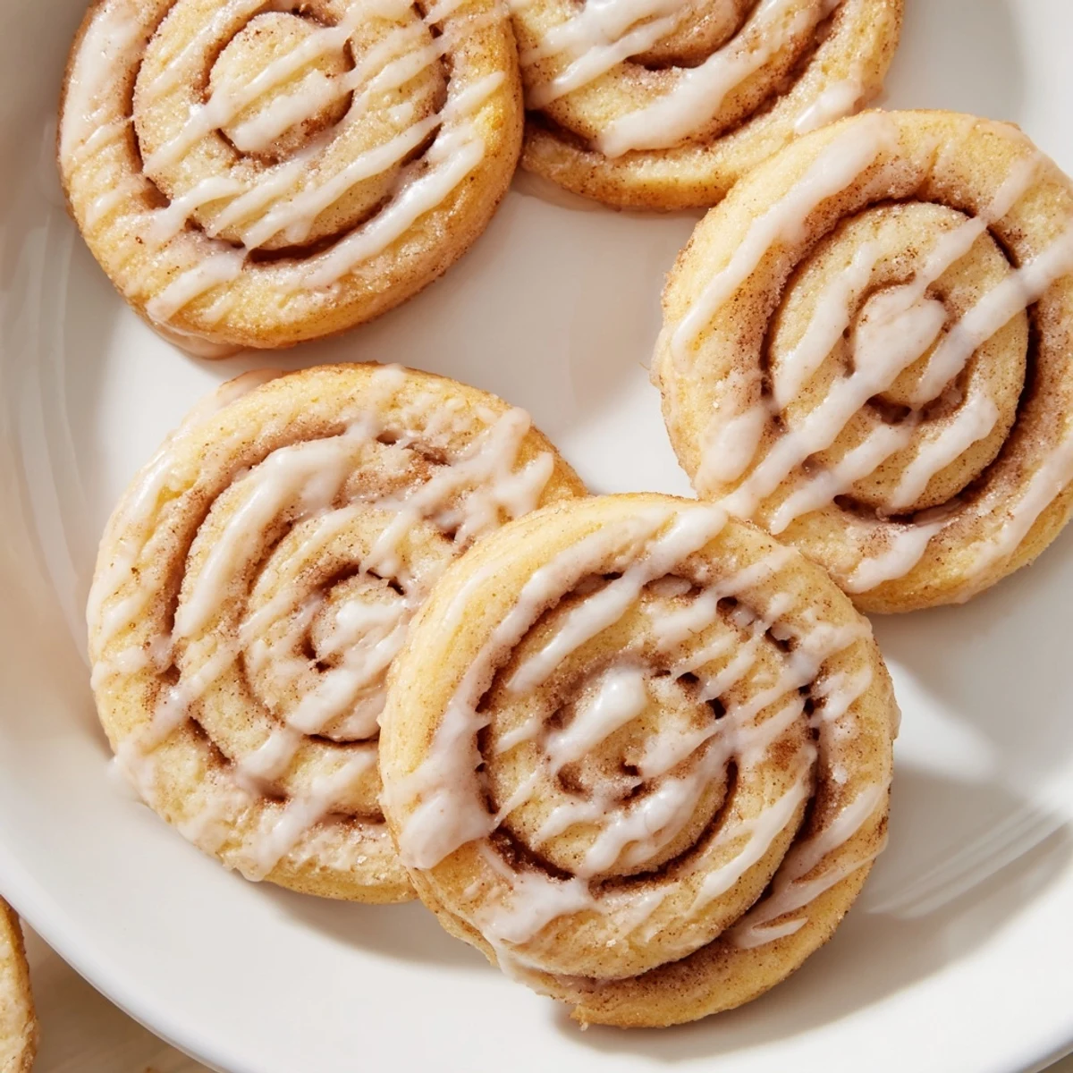 Freshly baked Cinnamon Roll Cookies with a rich cinnamon filling and glossy glaze, perfect for a sweet snack or dessert on a marble countertop.
