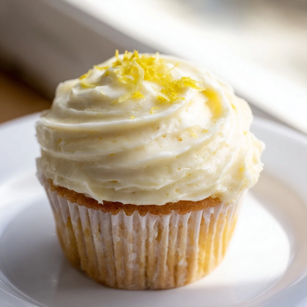 Golden-brown Elderflower Cupcakes brushed with syrup, displayed on a rustic wooden board in natural light.