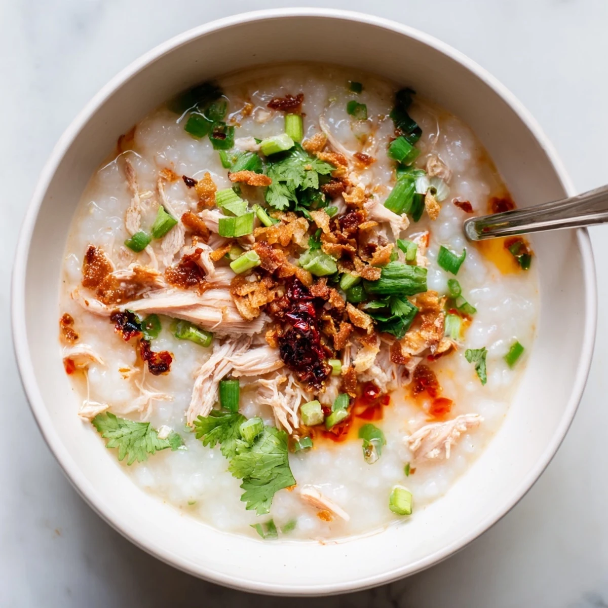 Comforting rice porridge made with leftover Thanksgiving turkey, garnished with boiled egg slices and crispy fried garlic