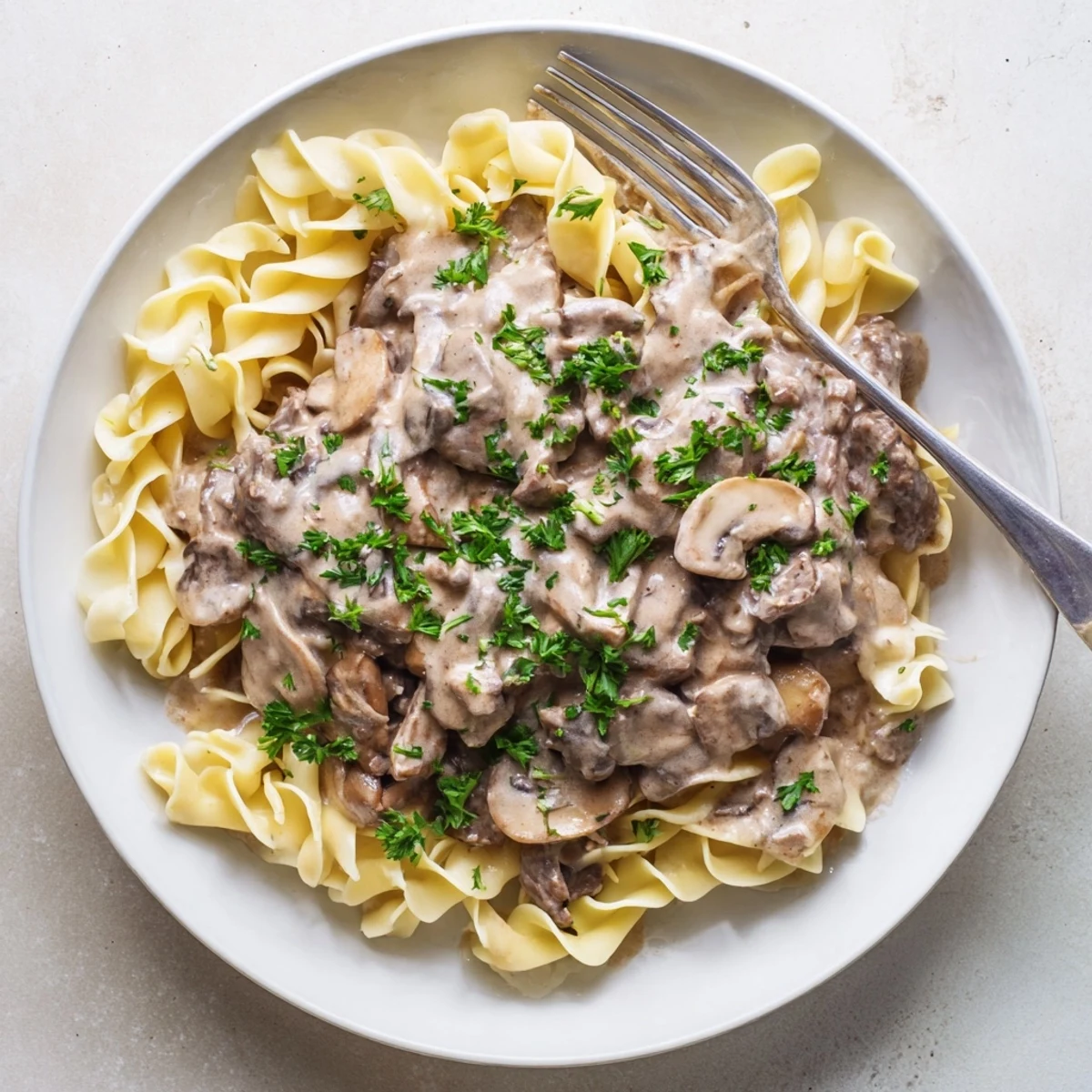 Savory beef strips and earthy mushrooms swimming in rich sour cream sauce over pasta