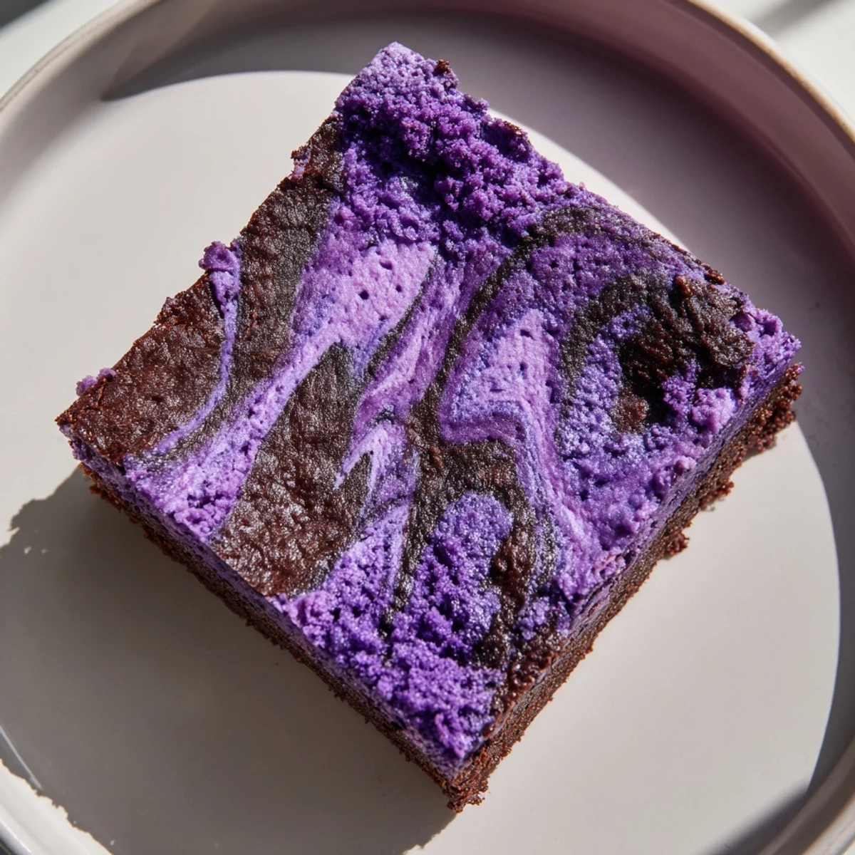 Square slices of rich ube brownies topped with white chocolate chips and coconut