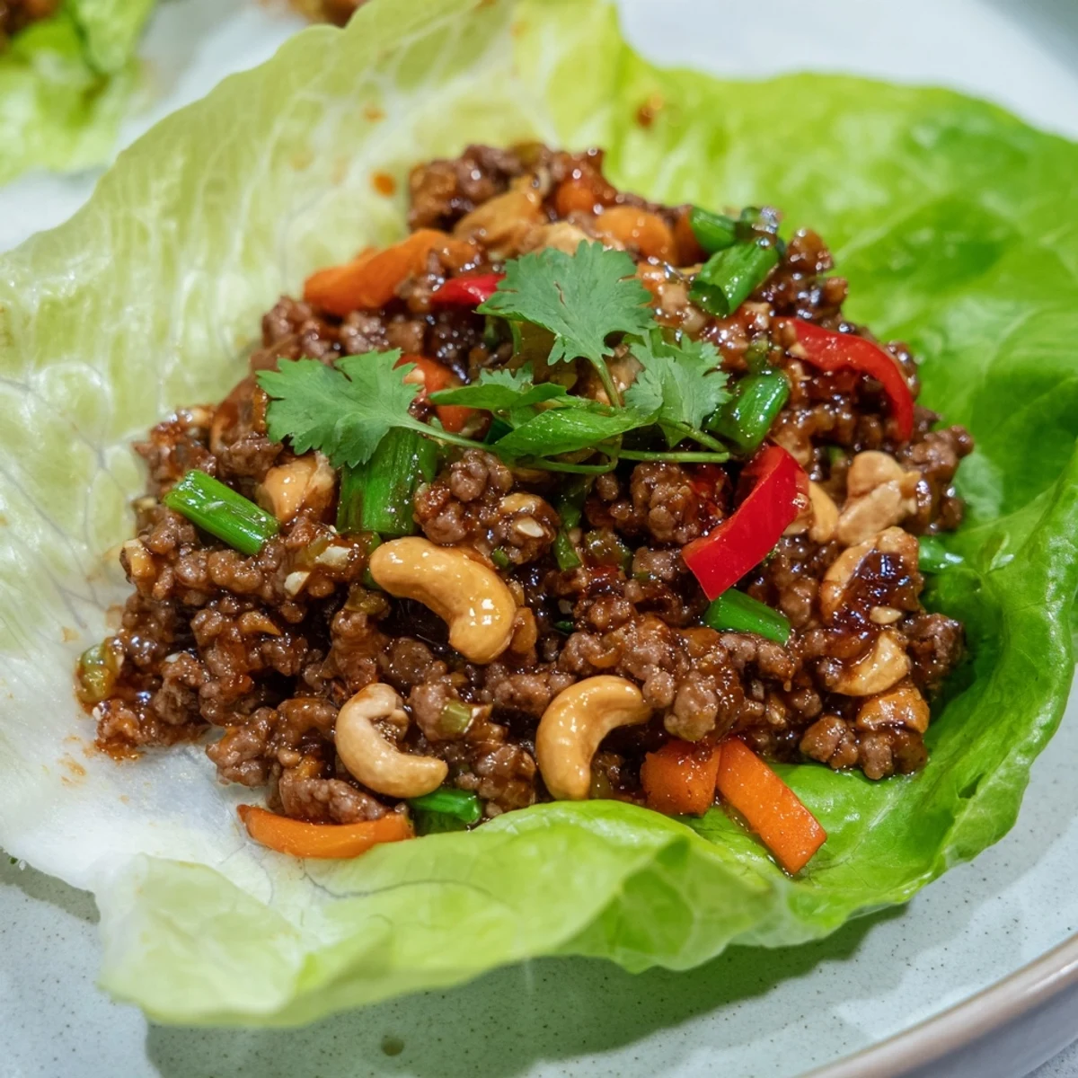 Tender Asian-style beef mixture with roasted cashews inside crisp lettuce wraps