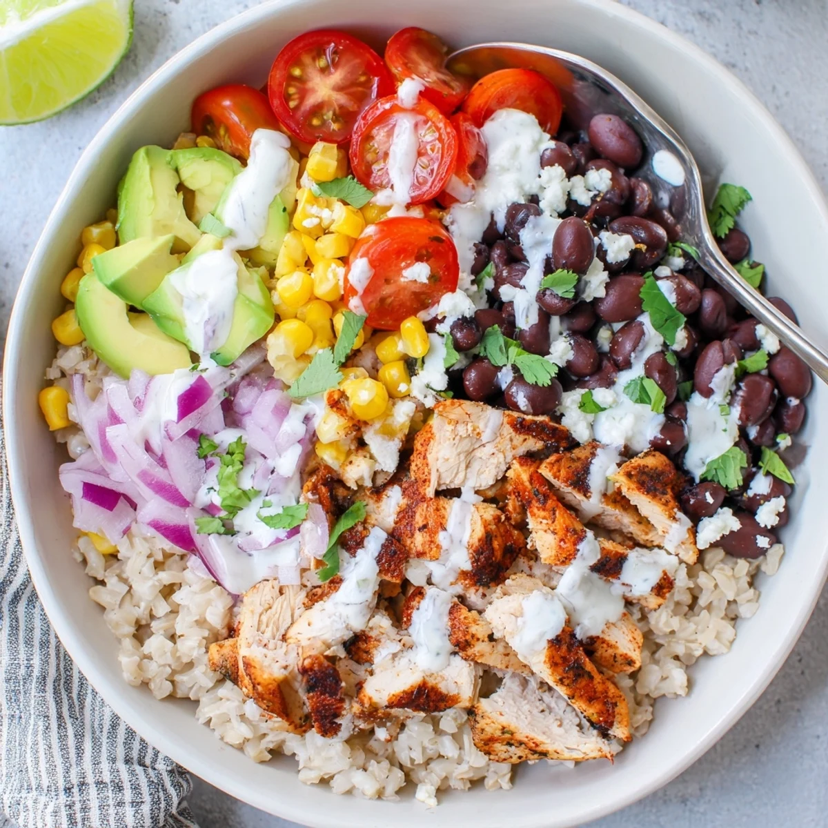 Vibrant Mexican-inspired protein packed street corn chicken bowl with avocado, black beans, and cotija