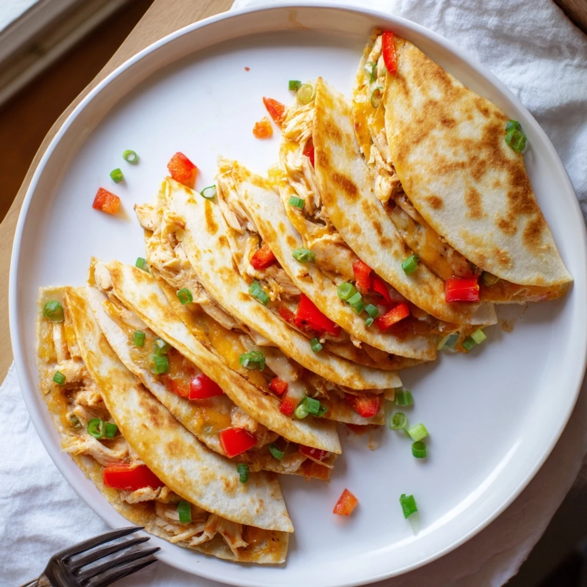 Crispy oven-baked quesadillas cut into wedges, revealing spiced chicken and vegetables inside