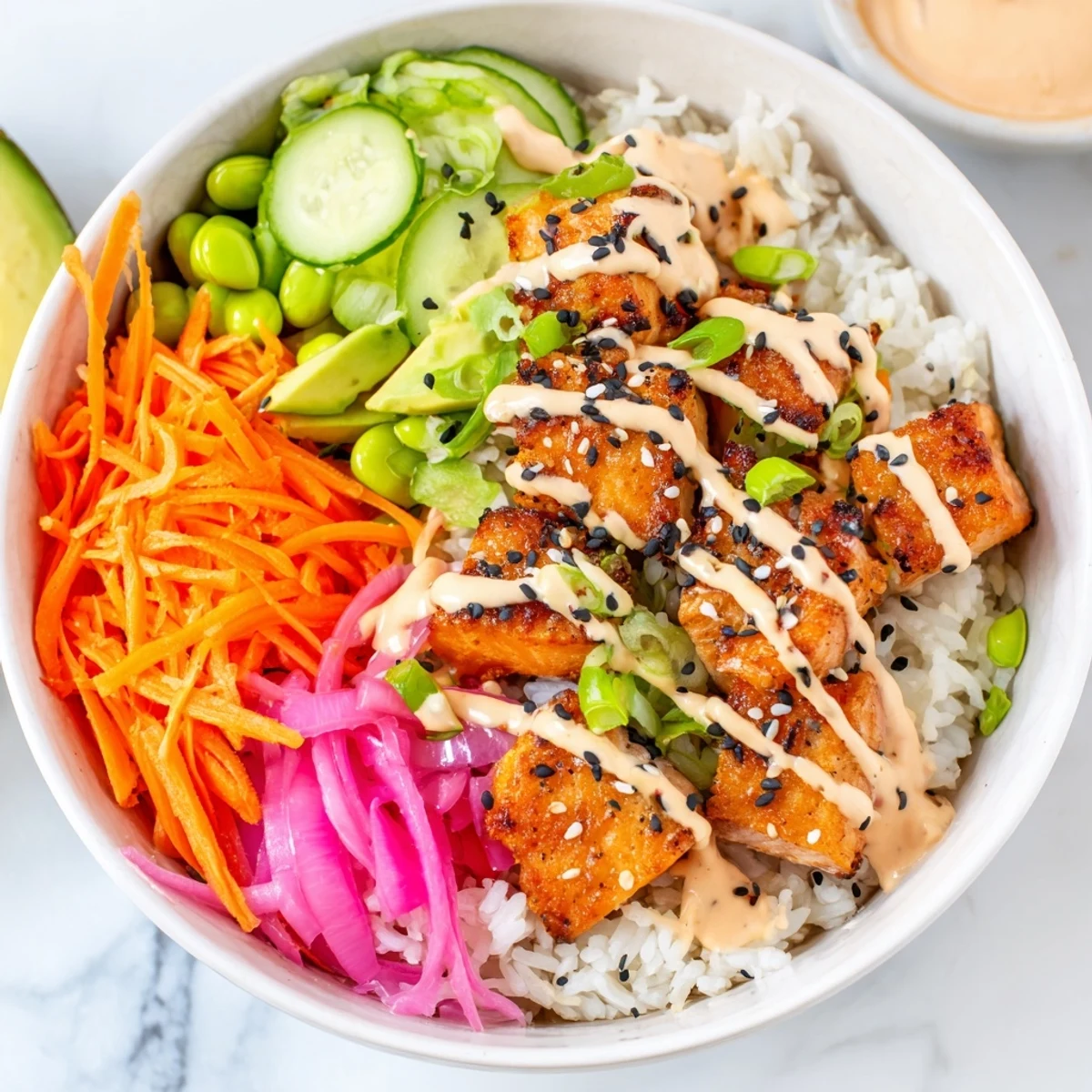 Healthy easy salmon bowl featuring crisp cucumber, edamame, carrots, and sesame seed garnish