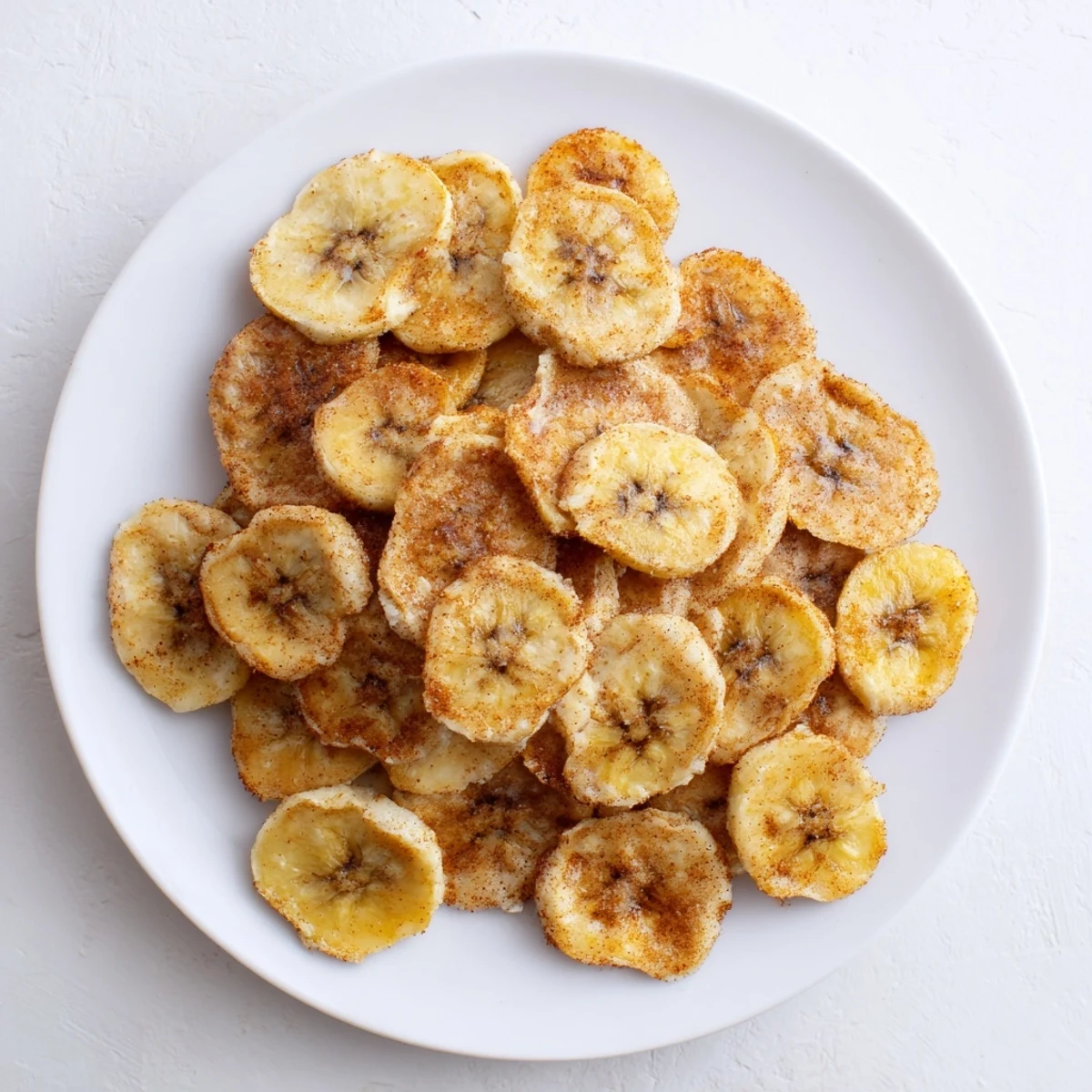 Bowl of air fryer banana chips coated in sweet cinnamon sugar perfect for healthy snacking
