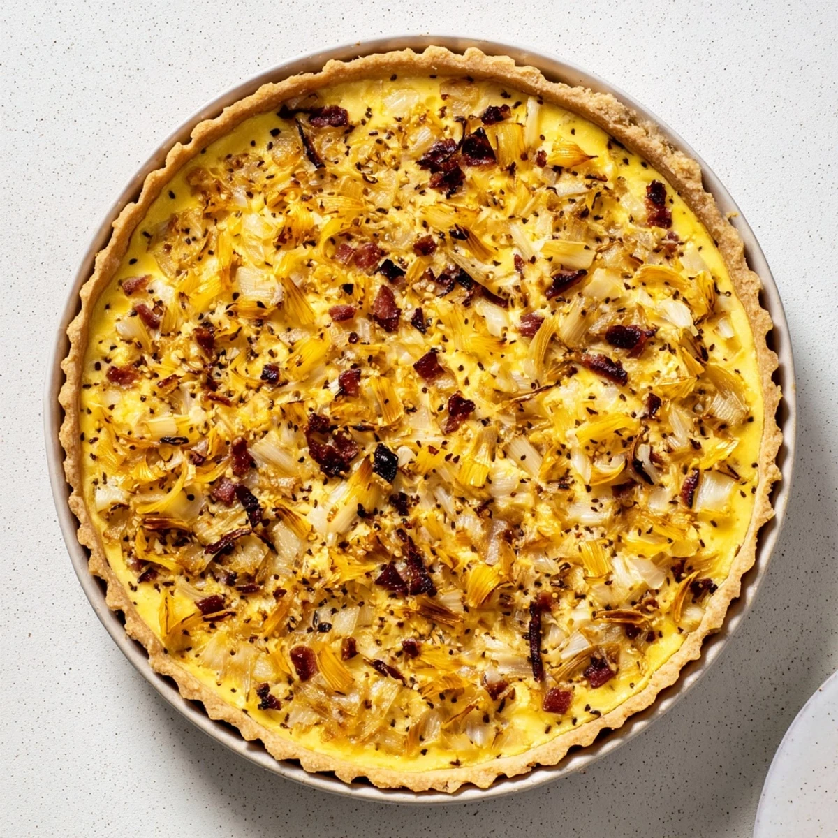 Golden German onion pie with caramelized onions and bacon in flaky pastry crust