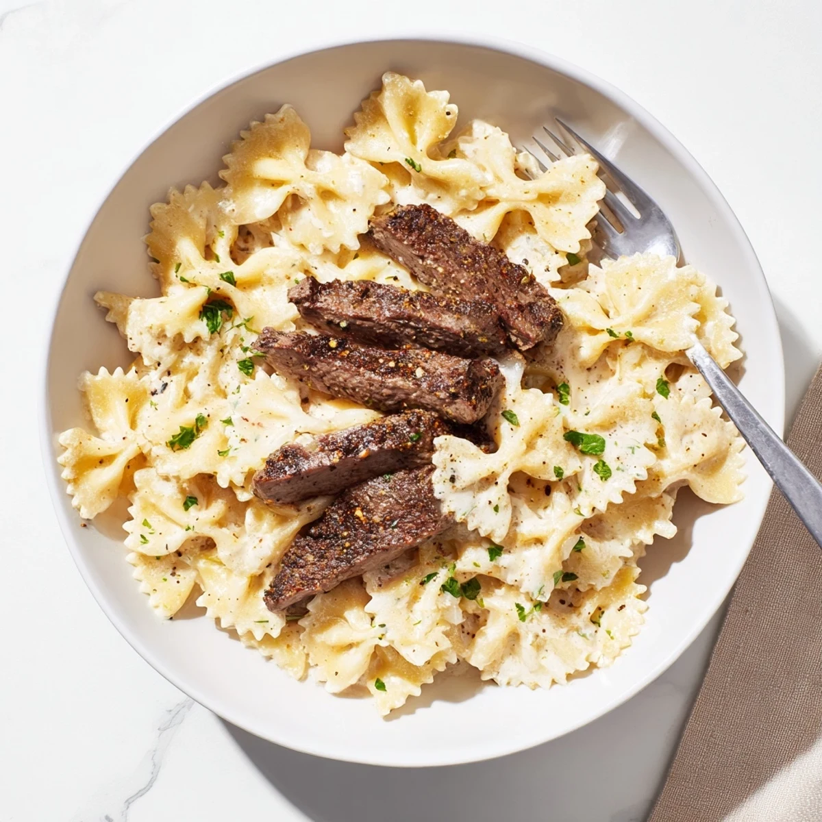 Tender farfalle pasta coated in Cajun cream cheese sauce with spiced beef and Parmesan