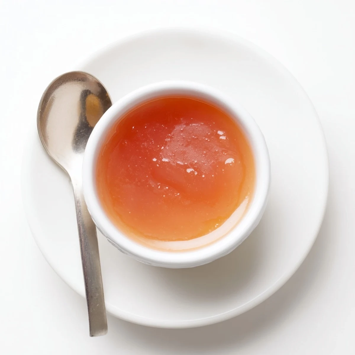 Rich McDonalds sweet and sour sauce drizzled over crispy chicken tenders on a dark plate