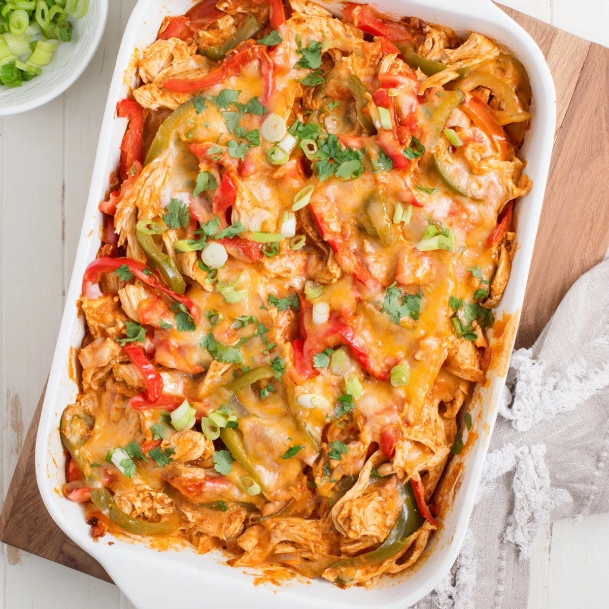 Golden cheesy chicken fajita casserole bubbling with colorful peppers and melted Mexican cheese