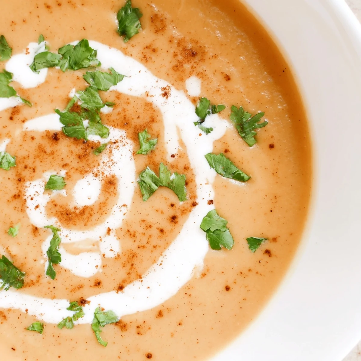 Creamy Spicy Apple Soup Recipe garnished with coconut cream and fresh herbs