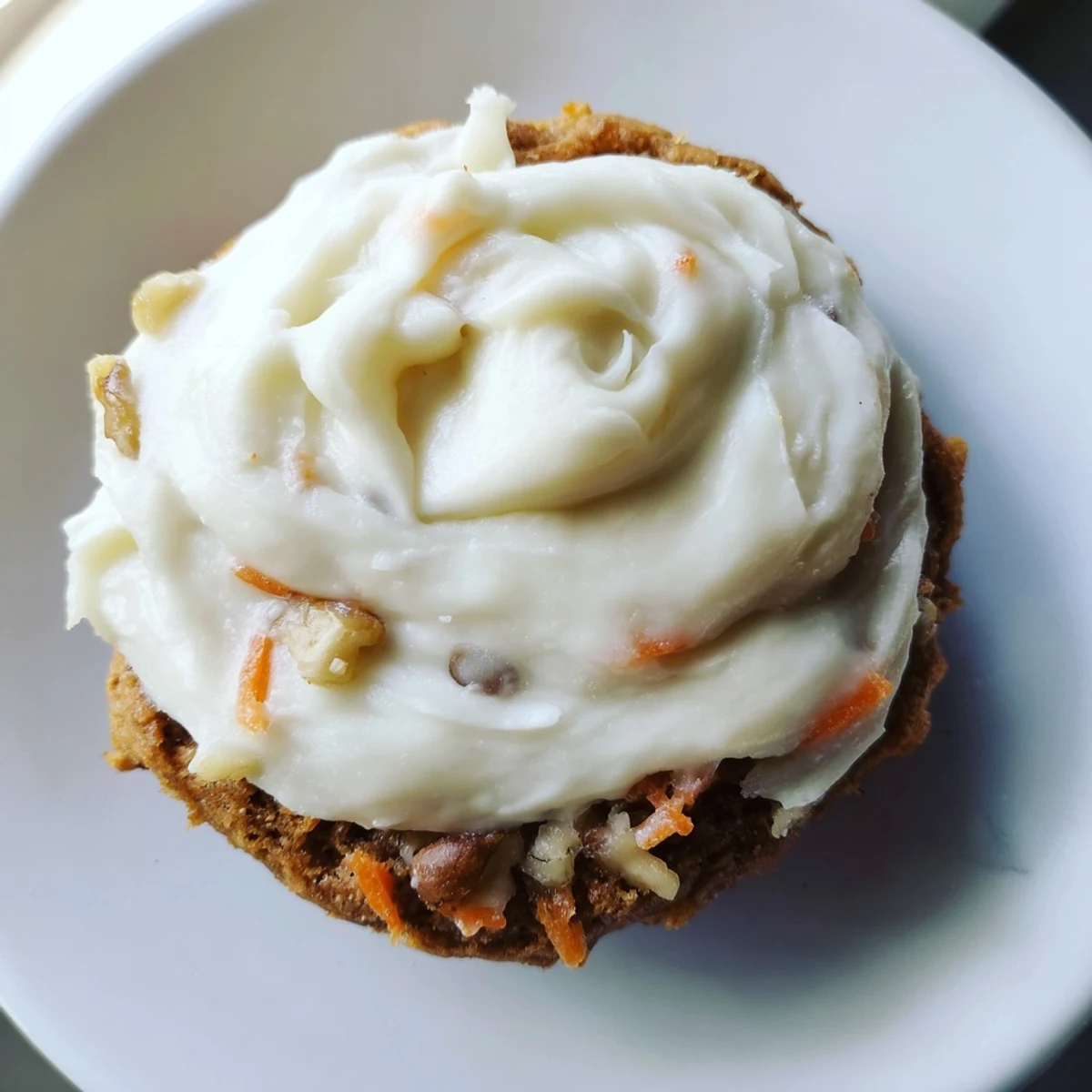 Soft frosted Crumbl carrot cake cookies topped with swirls of tangy cream cheese frosting