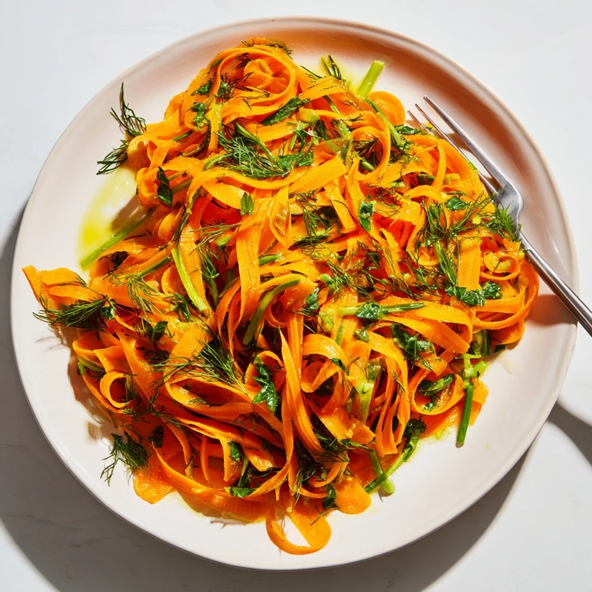 Crisp marinated carrot salad glistening with lemon dill dressing in a serving bowl