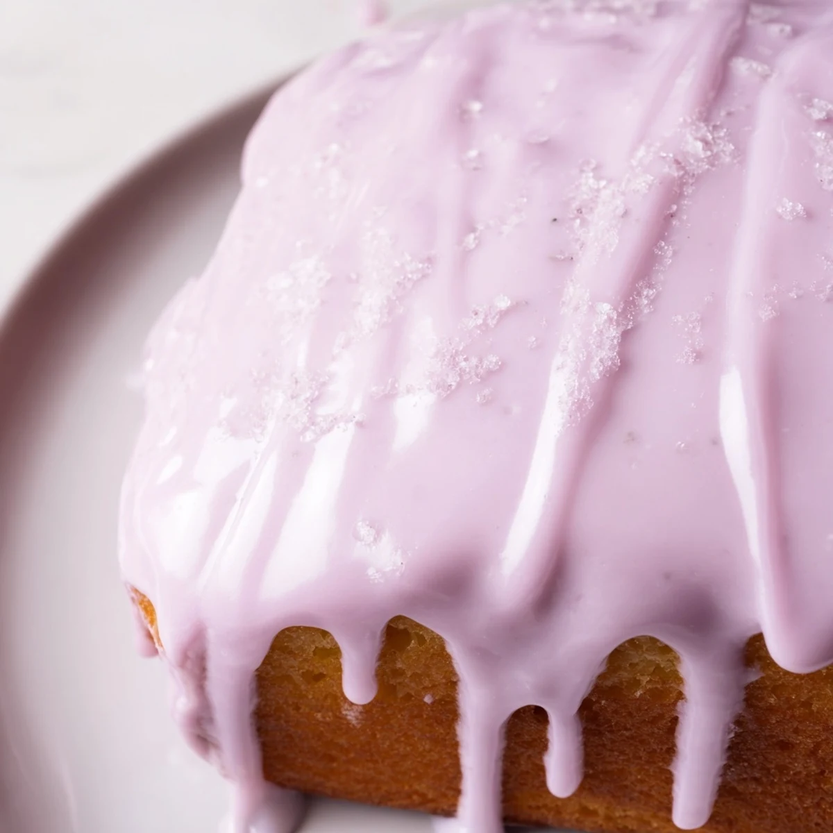 Smooth purple lavender glaze drizzled over freshly baked scones on a rustic white plate