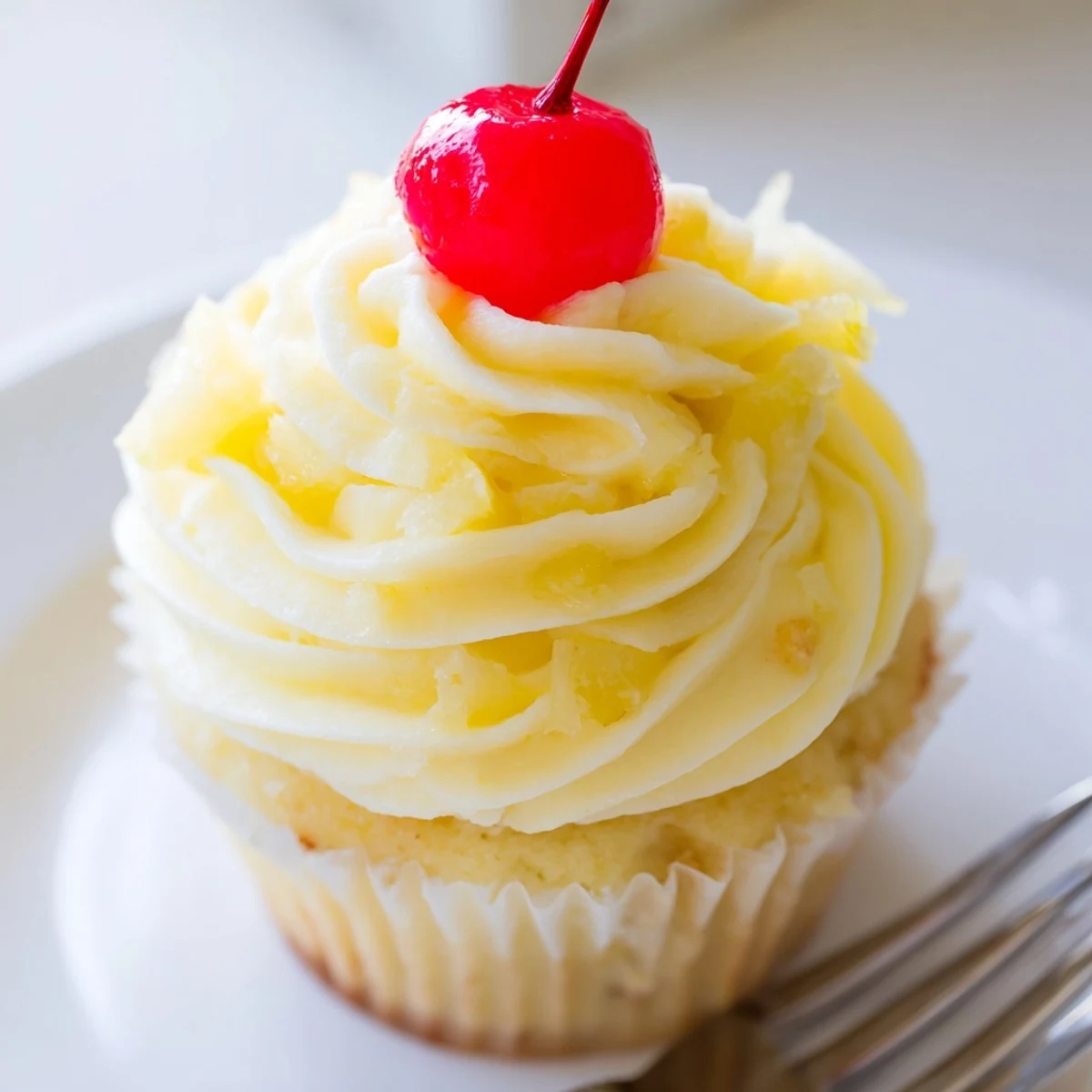 Tropical Dole Whip Cupcakes with creamy yellow frosting and a fresh pineapple wedge