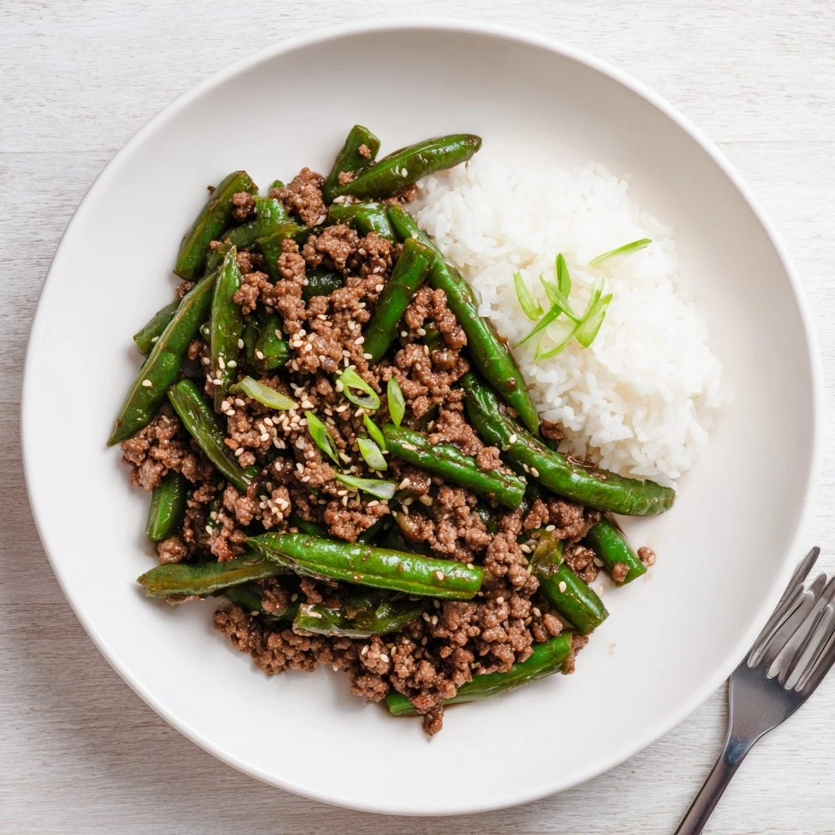 Chinese Green Beans and Ground Beef sizzling in wok, glossy garlic soy glaze
