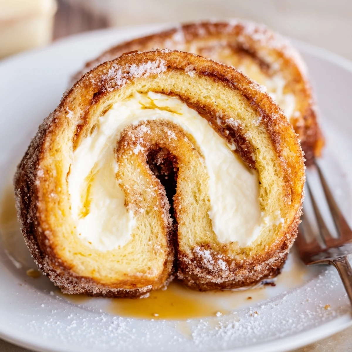 Buttered skillet browning Cinnamon Roll French Toast Roll Ups, served hot with maple syrup
