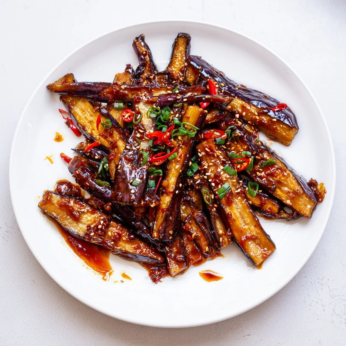 Silky, spicy Sichuan Style Braised Aubergines glistening in aromatic red sauce