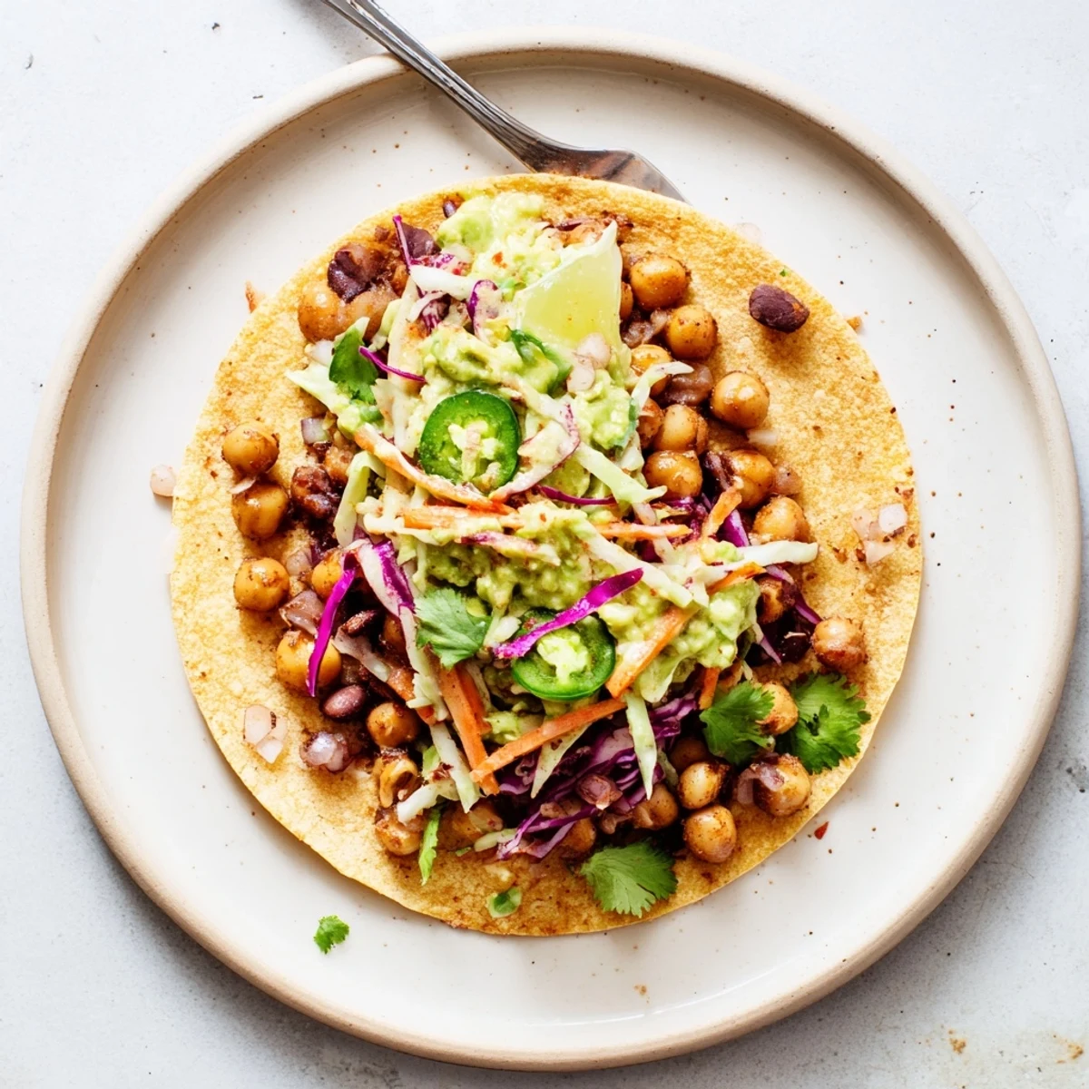 Chickpea Black Bean Tacos with Creamy Avocado Slaw served with sliced jalapeños
