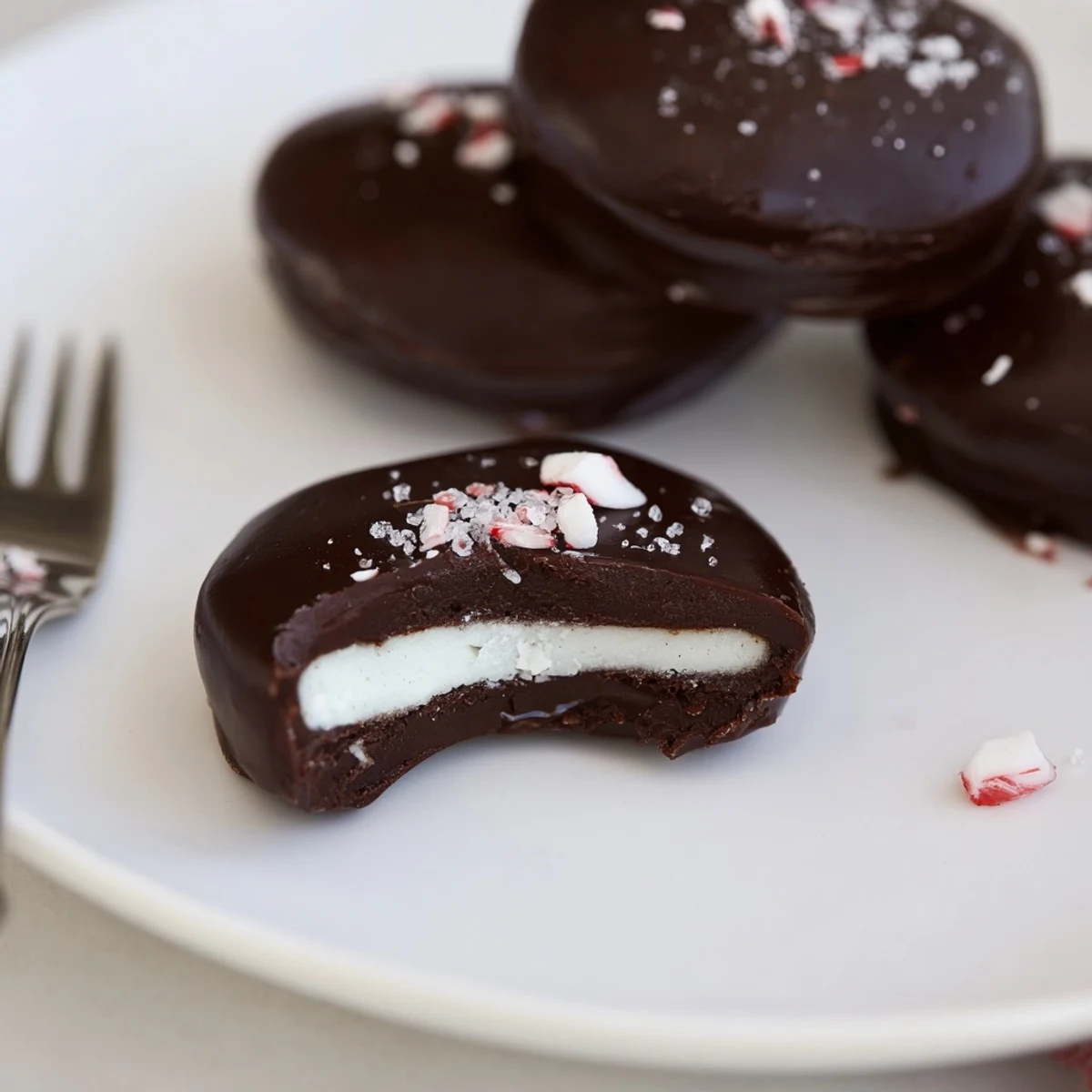 Fork-dipped Peppermint Patties resting on cooling rack, smooth mint center.