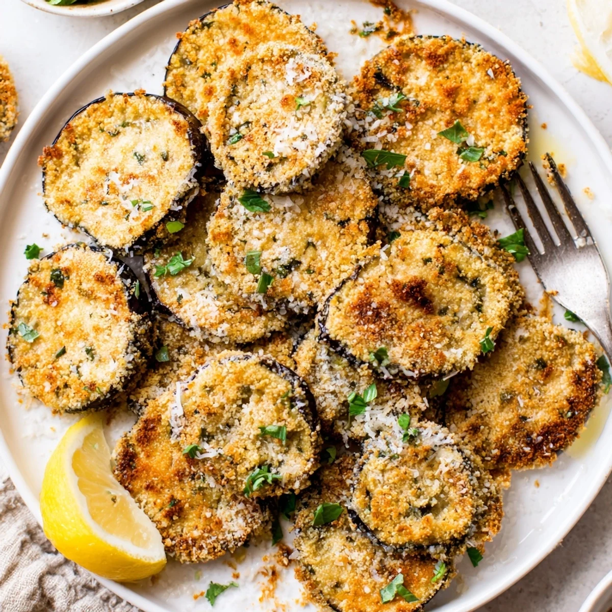 Stacked Garlic Herb Crusted Eggplant Slices, browned edges, ready for lemon squeeze