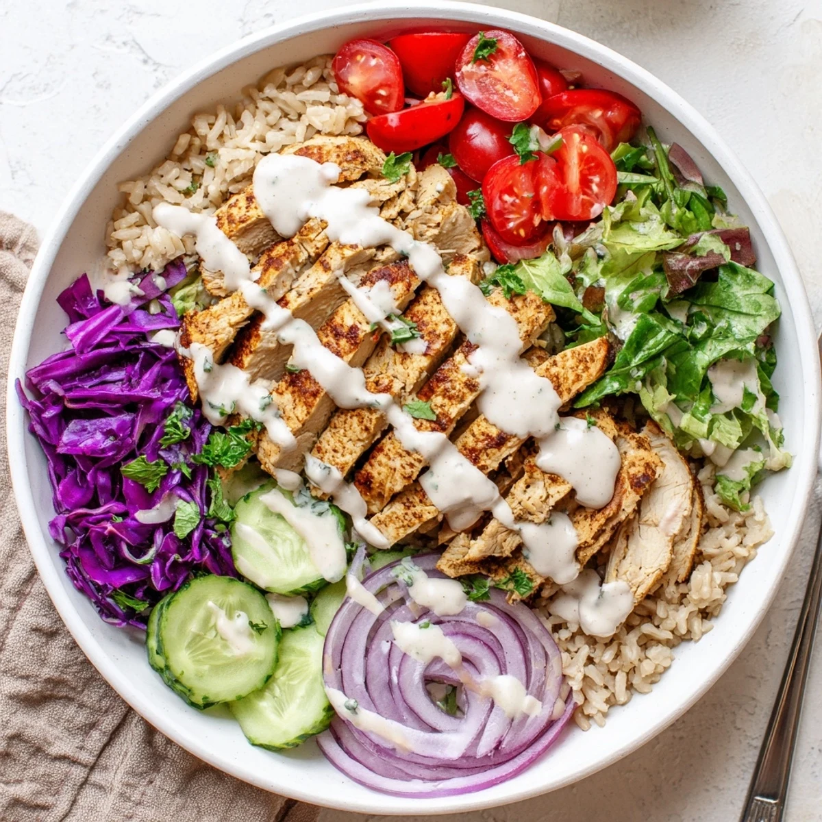 Spiced chicken shawarma bowl packed with wholesome grains, crisp veggies, and velvety tahini yogurt sauce